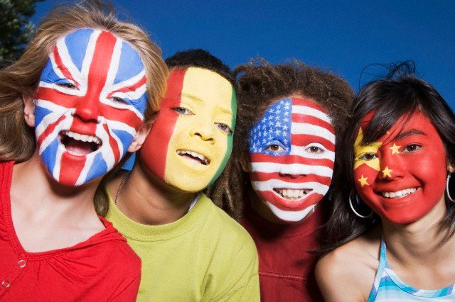 Children with United Kingdom, Guinean, United States and Chinese flags painted on faces